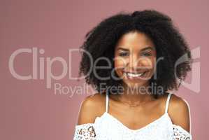 I just cant help but to smile. a beautiful young woman smiling against a pink background.