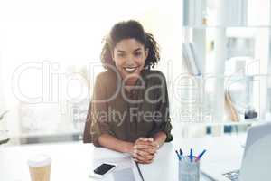 Welcoming you to another year of success and prosperity. Portrait of a confident young businesswoman sitting at her desk in a modern office.