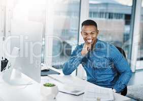 Always be on top of your game. Portrait of a young businessman posing and in good spirits at his office desk.