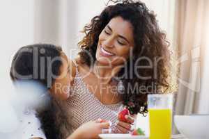 I guess were about to have a fruitful day today. a young mother and her daughter enjoying breakfast together at home.