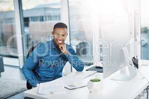 Challenge yourself every day. Portrait of a young businessman posing and in good spirits at his office desk.