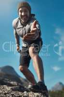 Always there to lift you up. Low angled portrait of a middle aged man reaching out his hand while hiking in the mountains.