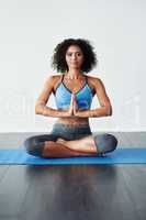 Yoga helps reduce stress. Studio shot of an athletic young woman practicing yoga against a grey background.