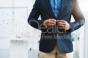 The boss is here. Closeup shot of an unrecognizable businessman fastening a button on his blazer in an office.