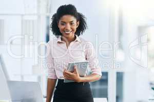 Heading into the next meeting with my trusty device. Portrait of a young businesswoman holding a digital tablet in an office.