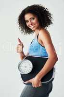Keep up the great work and keep working out. Studio shot of an athletic young woman holding a scale against a grey background.