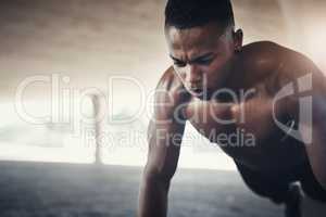 Building strength. a handsome young man doing pushups while exercising outside.