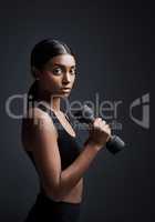 The journey to your fitness goals begins now. Studio portrait of a young sportswoman doing dumbbell exercises against a gray background.