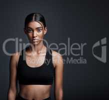 Train insane or remain the same. Studio portrait of a young sportswoman posing against a gray background.