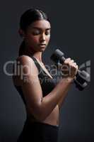 Always remember that strength is judged by perseverance not weight. Studio shot of a young sportswoman doing dumbbell exercises against a gray background.