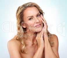 So soft... Studio portrait of an attractive mature woman posing against a grey background.