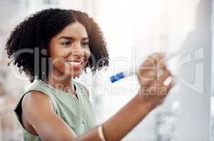 Shes a strategic thinker. an attractive young businesswoman working on a glass wipe board in her office.