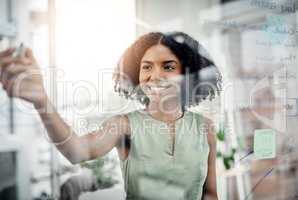 Planning and strategizing. an attractive young businesswoman working on a glass wipe board in her office.