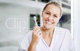 Theres only one whitening technique I believe in. a mature woman posing with a toothbrush.