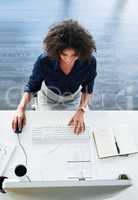 Shes diligent and focused. High angle shot of an attractive young businesswoman working at her desk in the office.