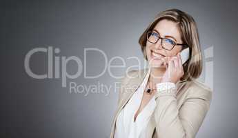 Connect with your clients, they want to hear from you. Studio portrait of a young businesswoman using a mobile phone against a gray background.