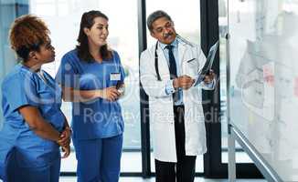 It doesnt hurt getting a second or third opinion. a team of doctors discussing the results of an X-ray in a hospital.