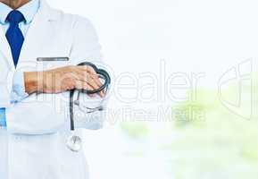 Your health is his only concern. an unrecognizable male doctor standing with his arms folded inside of a hospital during the day.