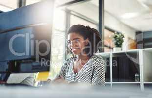 Her poise and self-assuredness is appreciated. a young businesswoman working on her computer at her desk.