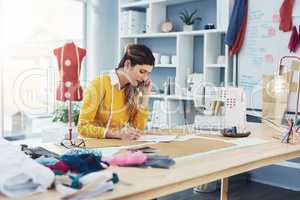 Tailor made success. an attractive young fashion designer in her workshop.