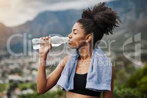 Water purifies the body and soul. a sporty young woman drinking water while exercising outdoors.