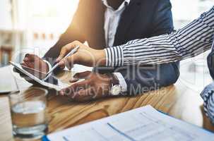 The internet is always there to help. Closeup shot of two businesspeople working together on a digital tablet in an office.