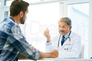 Theres one little issue that I need to bring to your attention. a confident mature male doctor consulting with a patient inside of his office during the day.