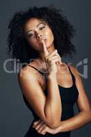 Its no big secret that you define your beauty. Studio shot of a beautiful young woman posing against a dark background.