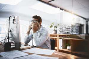 My brain just cant function anymore. a young businessman looking exhausted while working late on a computer in an office.