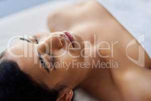 When the effects of a luxurious spa experience lingers. an attractive young woman relaxing on a massage table at a spa.