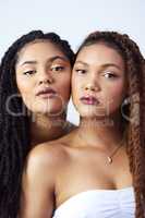 Naturally beautiful. Studio shot of two beautiful young women posing against a grey background.