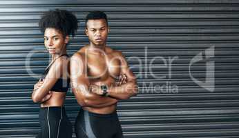 Never underestimate your determination. Portrait of a sporty young couple standing together against a grey background.