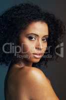 The flawless face of femininity. Studio shot of a beautiful young woman posing against a dark background.