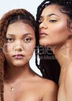 Together they glow. Studio shot of two beautiful young women posing against a grey background.