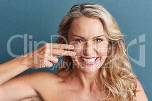 It definitely makes a difference. Studio portrait of an attractive mature woman applying moisturizer against a grey background.