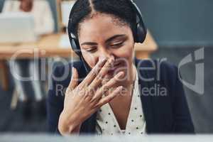 Young call centre agent covers their mouth to hide their smile. The client makes the employee happy with their positive feedback or joke. Building a professional and friendly relationship online.
