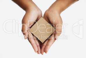 Closeup of the hands of a person showing a message, advertising a product or holding an empty paper or a cardboard card against a white background. Top view of woman promoting an item or sign