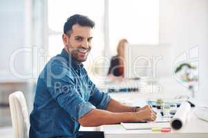 Happy creative businessman working at his desk, doing admin and taking notes while in an office at work. Portrait of a cheerful, smiling and professional male with a positive attitude and expression