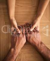 Man and woman holding hands sharing feelings of love, support and trust together on a table. Closeup of a loving couple expressing care, promise and compassion to overcome problems