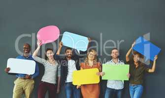 Smiling casual team of diverse people holding opinion speech bubbles, to voice their important communication message. Creative group standing with colorful copyspace sign boards together in a row