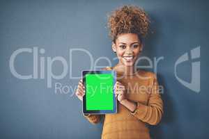 African female holding green screen tablet copyspace. Cute, attractive and smiling young afro woman standing and showing a mobile device.Happy, cheerful and ethnic woman after buying new app.