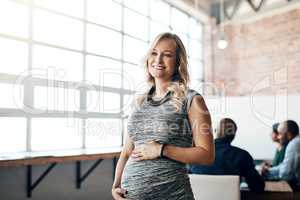 Pregnant business woman leader, working and smiling in a modern office during a meeting. Having one last meeting before her maternity leave starts. Happy confident and attractive mother to be.