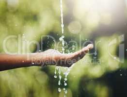 Hygiene, washing and saving water with hands against a green nature background. Closeup of one person holding out their palm to save, conserve and refresh with water in a park, garden or backyard