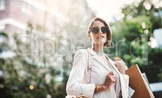 Elegant woman holding shopping bags after a spending spree, retail therapy and buying clothes in a city. Trendy, stylish and fashionable lady purchasing gifts, presents and classy clothing downtown