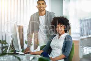 Happy manager or leader helping an employee on a computer to plan ideas or business growth strategy. African female intern or trainee working for a startup and training in the IT department