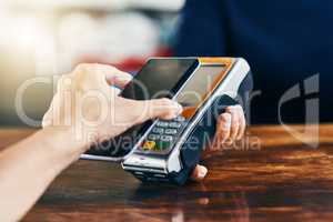 Its as easy as taking your phone out. Closeup of an unrecognizable person using her phone to scan and pay a bill on a card machine at a cafe during the day.