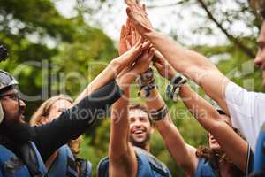 Lets go. a group of young friends high fiving while out white water rafting.