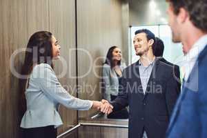 They came to the conference to meet businesspeople. businesspeople meeting and greeting in an elevator.