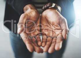 Your assistance is needed. Closeup shot of an unrecognizable businessman standing with his hands cupped together.