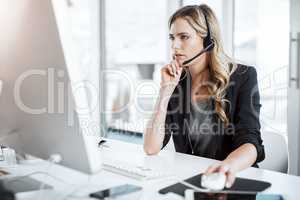 Ive found the solution to your query. a young woman using a headset and computer at her desk in a modern office.